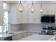 Contemporary kitchen featuring modern globe pendants, quartz counters and white cabinets at 11089 N 130Th Pl, Scottsdale, AZ 85259