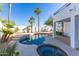 Backyard swimming pool, spa, desert landscaping, and mature palm trees at 11089 N 130Th Pl, Scottsdale, AZ 85259