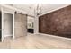 Elegant bedroom with hardwood floors, accent wall, and barn door that leads to the en suite bathroom at 1255 N Arizona Ave # 1300, Chandler, AZ 85225