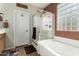 Bright bathroom featuring a glass shower, soaking tub, and decorative glass block window at 1474 E Locust Dr, Chandler, AZ 85286