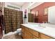 Bathroom with a decorative shower curtain, single sink vanity, and warm-toned walls at 1474 E Locust Dr, Chandler, AZ 85286