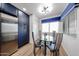 Bright dining area features a glass table with 4 chairs, blue valances and wood floors at 15225 N 100Th St # 1185, Scottsdale, AZ 85260
