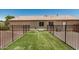 Backyard featuring artificial turf, dog run, and black wrought iron fence at 1583 N Constellation Ct, Gilbert, AZ 85234