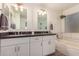 Well-appointed bathroom featuring double sinks, elegant mirrors, and a relaxing soaking tub for a luxurious experience at 1583 N Constellation Ct, Gilbert, AZ 85234
