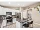 Modern kitchen featuring stainless steel appliances, a center island with seating, and white cabinetry at 1583 N Constellation Ct, Gilbert, AZ 85234