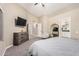 Well-lit main bedroom with high ceilings, a large dresser, cozy seating, and convenient access to the en-suite bathroom at 1583 N Constellation Ct, Gilbert, AZ 85234