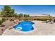 A freeform pool with rock features is the centerpiece of this backyard at 1583 N Constellation Ct, Gilbert, AZ 85234