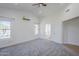 Bright primary bedroom boasting plush neutral carpet, a ceiling fan, and backyard views at 1616 N 125Th Ln, Avondale, AZ 85392