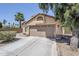 Tan single-story home featuring a two-car garage and low maintenance desert landscaping at 1616 N 125Th Ln, Avondale, AZ 85392