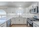 Bright kitchen with white cabinets, stainless steel appliances, and a marble backsplash at 1616 N 125Th Ln, Avondale, AZ 85392
