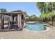 A sparkling swimming pool surrounded by lush greenery and a charming gazebo with privacy drapes at 1616 N 125Th Ln, Avondale, AZ 85392