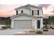 Charming two-story home with a two-car garage and desert landscaping at sunset at 17388 W Jessie Ln, Surprise, AZ 85387