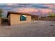 View of the backyard featuring a covered patio area with a stucco privacy wall and space for landscaping at 18108 W Cassia Way, Goodyear, AZ 85338