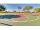 Outdoor basketball court in community park, surrounded by lush green landscape and mature trees at 18108 W Cassia Way, Goodyear, AZ 85338