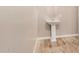 Elegant powder room featuring a pedestal sink and stylish flooring, creating a welcoming space at 18108 W Cassia Way, Goodyear, AZ 85338