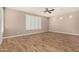 Bright bedroom featuring wood-look tile flooring, plantation shutters, and a ceiling fan at 18108 W Cassia Way, Goodyear, AZ 85338