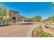 Stone clubhouse exterior with lush landscaping, palm trees, and desert views at 18108 W Cassia Way, Goodyear, AZ 85338