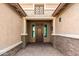 The stately covered entryway has decorative brick and a beautiful wooden door at 18108 W Cassia Way, Goodyear, AZ 85338