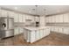 Stylish kitchen featuring stainless steel appliances, a granite island, and ample white cabinet space at 18108 W Cassia Way, Goodyear, AZ 85338