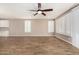 Spacious living area with tile floors, ceiling fan, and large windows with shutters at 18108 W Cassia Way, Goodyear, AZ 85338