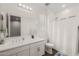 Bright bathroom with double sinks, white cabinets, and a shower behind a curtain at 20904 E Swan Dr, Queen Creek, AZ 85142