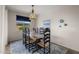 Dining area features a rustic table, six chairs, stylish pendant light, and a view of the front yard at 20904 E Swan Dr, Queen Creek, AZ 85142