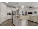 Bright kitchen featuring a central island with a sink, modern appliances, white cabinets, and an open view into the living area at 20904 E Swan Dr, Queen Creek, AZ 85142