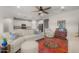 Open-concept living area featuring a large sectional sofa, vibrant rug, and direct view into the modern white kitchen at 20904 E Swan Dr, Queen Creek, AZ 85142