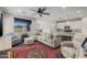 Inviting living space featuring a plush sectional sofa, vibrant rug, ceiling fan, and a cozy armchair near a bright window at 20904 E Swan Dr, Queen Creek, AZ 85142