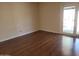 Bright, empty bedroom with hardwood floors and sliding doors to the backyard at 211 Bahia E Ln, Litchfield Park, AZ 85340