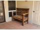 Outdoor patio area with a wooden bench, tiled floors, and neutral paint at 211 Bahia E Ln, Litchfield Park, AZ 85340