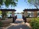 View of a pond from a shaded wooden deck with fountain and vegetation at 211 Bahia E Ln, Litchfield Park, AZ 85340
