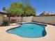 Backyard oasis featuring a private pool, mature trees, and perimeter fencing at 211 Bahia E Ln, Litchfield Park, AZ 85340