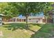 Spacious backyard features a lawn, detached structure, mature trees, and a covered patio at 216 E Harmont Dr, Phoenix, AZ 85020