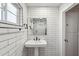 Stylish bathroom featuring subway tile walls, a black faucet, and a pedestal sink at 216 E Harmont Dr, Phoenix, AZ 85020