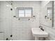 Updated bathroom featuring white subway tile, a pedestal sink and a glass shower at 216 E Harmont Dr, Phoenix, AZ 85020