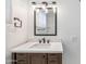 Bathroom vanity and mirror are illuminated by a modern light at 216 E Harmont Dr, Phoenix, AZ 85020