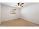 Neutral bedroom features a ceiling fan and a sunlit window at 216 E Harmont Dr, Phoenix, AZ 85020
