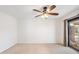 Carpeted bedroom featuring a ceiling fan and slider doors to the outdoor patio area at 216 E Harmont Dr, Phoenix, AZ 85020