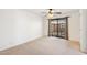 Spacious bedroom with light carpet, a ceiling fan and sliding doors to the patio at 216 E Harmont Dr, Phoenix, AZ 85020