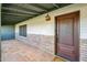 Inviting covered entrance featuring brick accents, a classic front door, and tiled flooring at 216 E Harmont Dr, Phoenix, AZ 85020