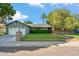 Charming single-Gathering home featuring a lush lawn, mature trees, and a brick-accented facade at 216 E Harmont Dr, Phoenix, AZ 85020