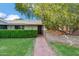 Inviting front yard with a brick walkway leading to a charming home entrance with manicured shrubs at 216 E Harmont Dr, Phoenix, AZ 85020