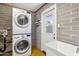 Practical laundry room with stacked washer/dryer, utility sink, and durable concrete block walls at 216 E Harmont Dr, Phoenix, AZ 85020