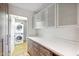 Well-organized laundry area adjacent to a kitchen with ample storage and countertop space at 216 E Harmont Dr, Phoenix, AZ 85020