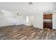 Open living room with wood-look tile, ceiling fan, and access to kitchen and bathroom at 216 E Harmont Dr, Phoenix, AZ 85020