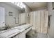 A neutral toned bathroom featuring a granite counter, updated vanity and neutral colored shower curtain at 2210 E Paraiso Dr, Phoenix, AZ 85024