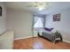 Comfortable bedroom with laminate floors, light-filled window, and a cozy single bed for relaxation at 2210 E Paraiso Dr, Phoenix, AZ 85024