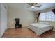 A bright bedroom with wood floors features a ceiling fan, large window, and comfortable living space at 2210 E Paraiso Dr, Phoenix, AZ 85024