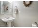 Charming half bathroom featuring a pedestal sink, decorative mirror, and floral accents for guests at 2210 E Paraiso Dr, Phoenix, AZ 85024